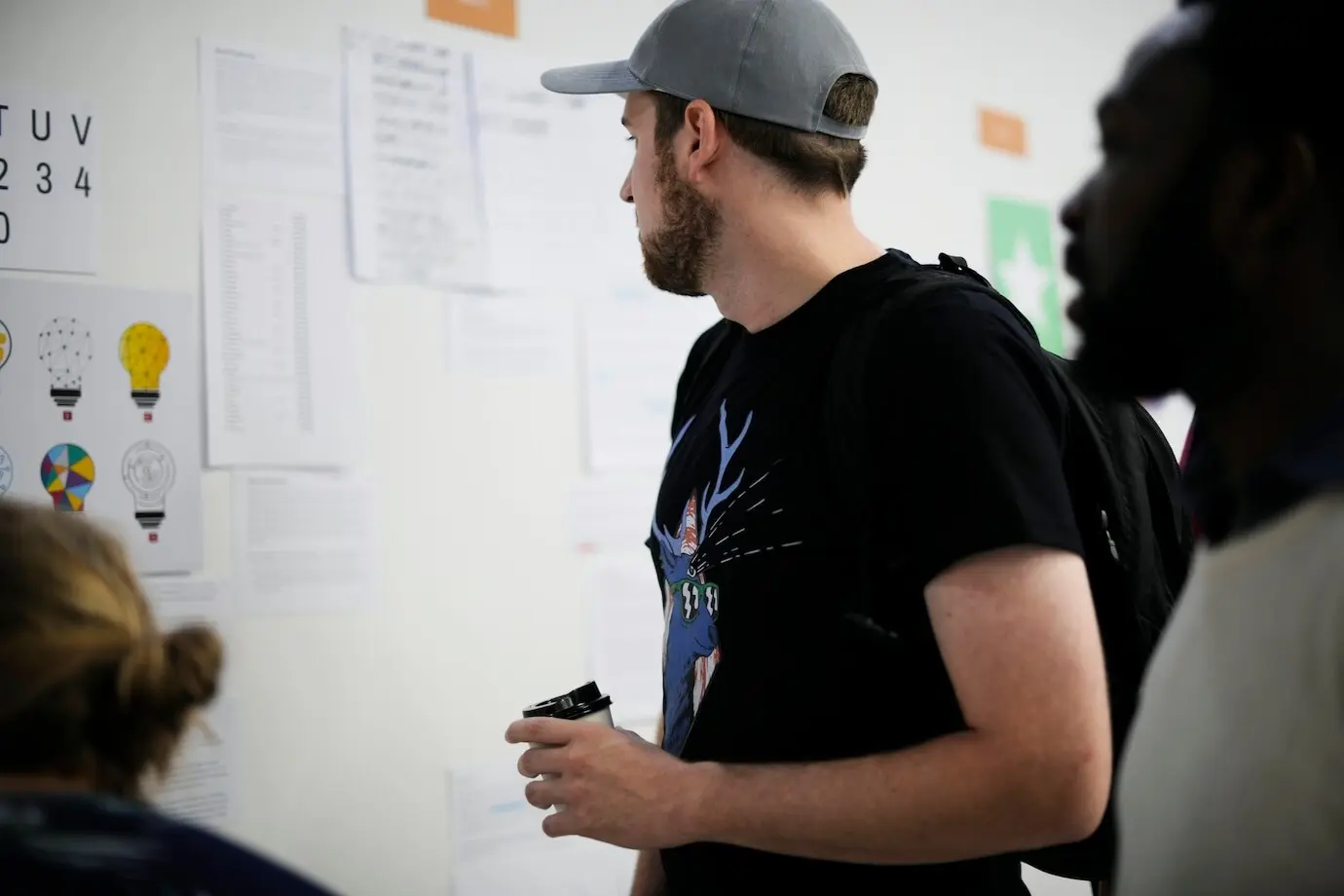 Люди из стартапа задумчиво смотрят на информацию на стратегической доске.